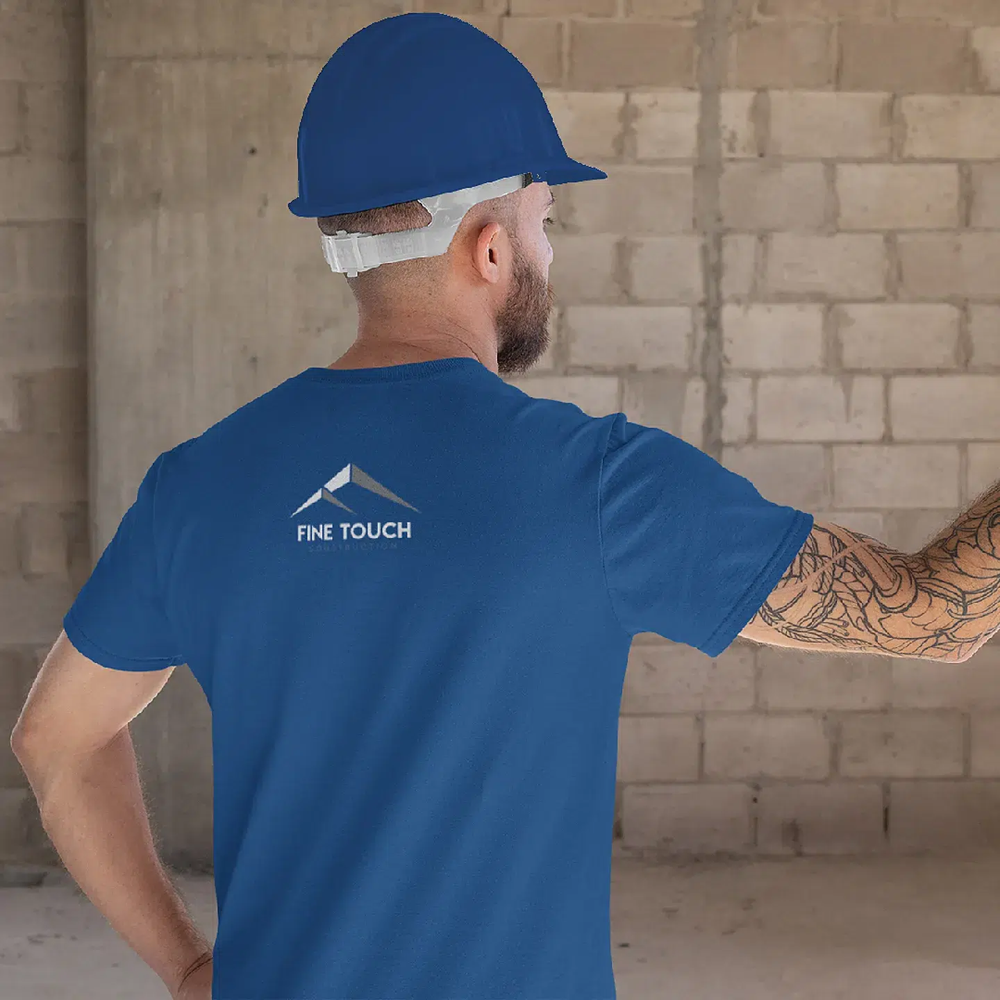 Worker wearing Fine Touch Construction branded cap and shirt