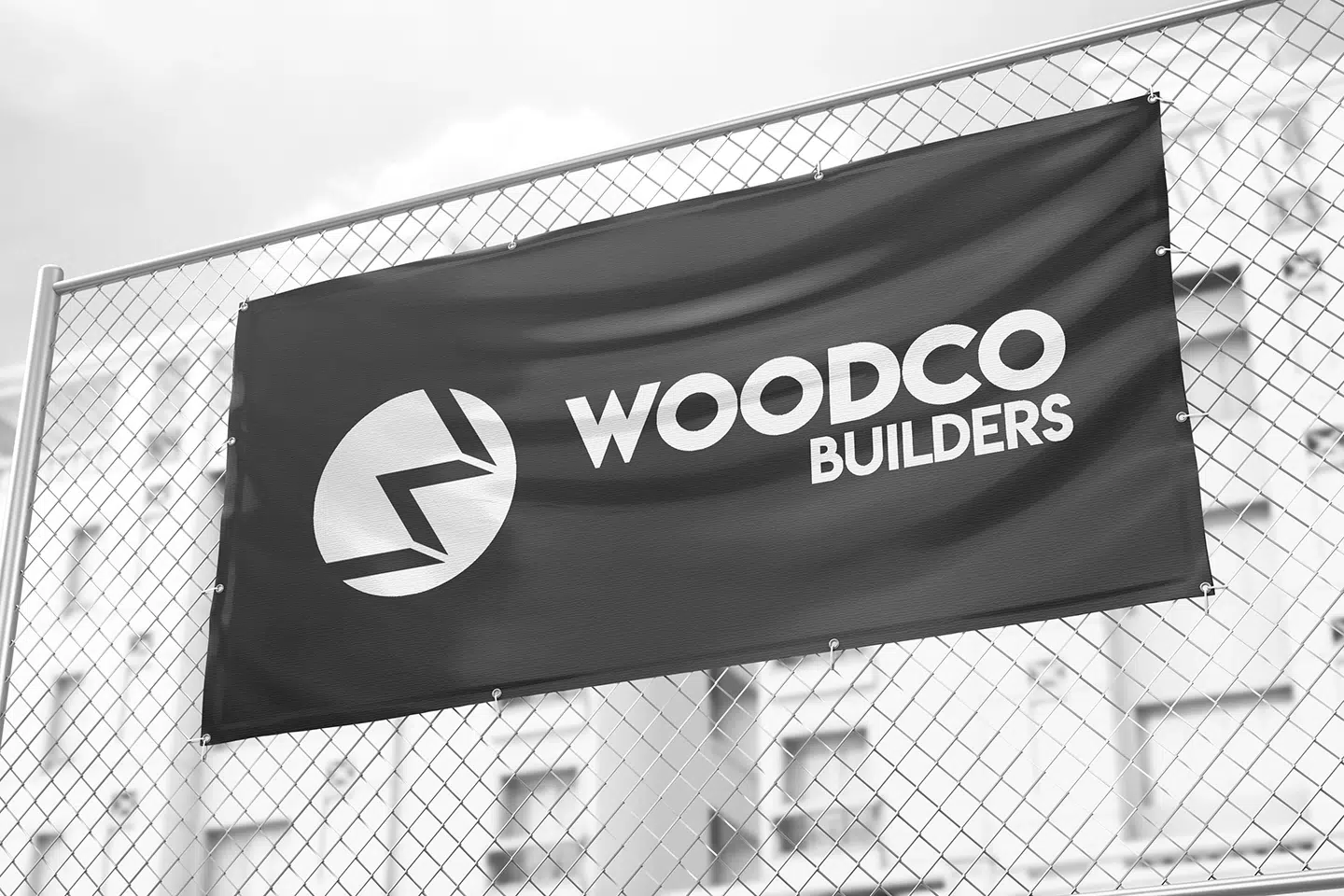 WoodCo Builders branded banner on a fence