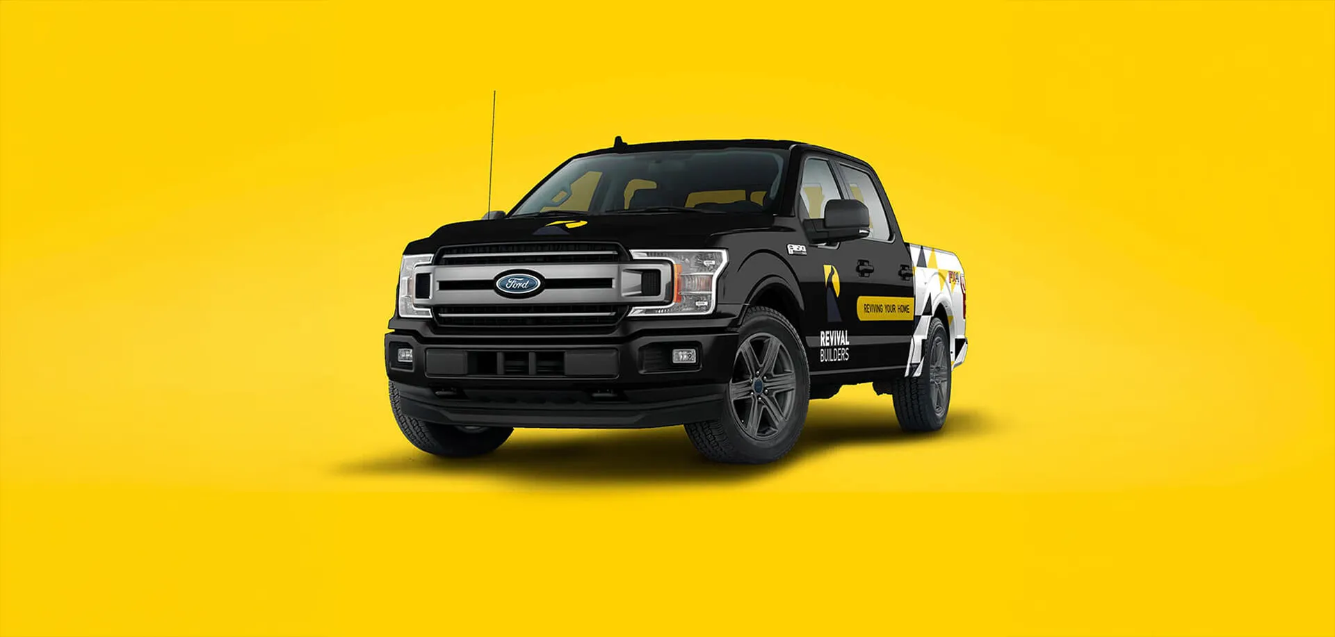 Black pickup truck with Revival Builders branding on a yellow background